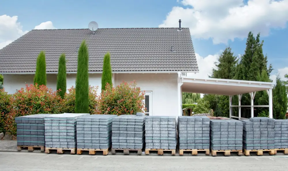 Landscaping materials on pallets in front of home.