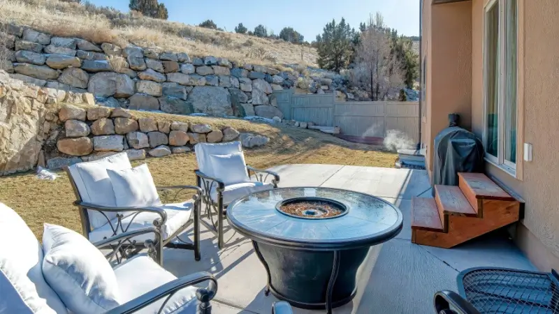 Backyard patio with retaining wall on slope.