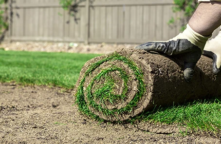 A person installing fresh sod.