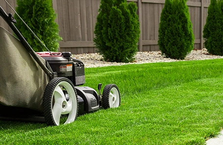 landscaper from the grounds guys of stone mountain mowing a residential lawn